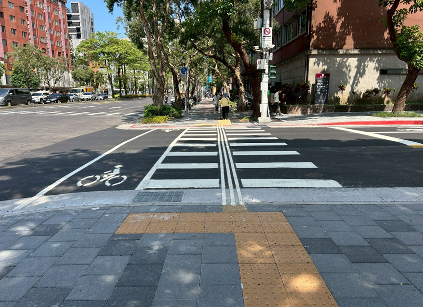 無障礙路口設計：設有黃色導盲磚導引路口方向，並有平緩坡道銜接斑馬線。
